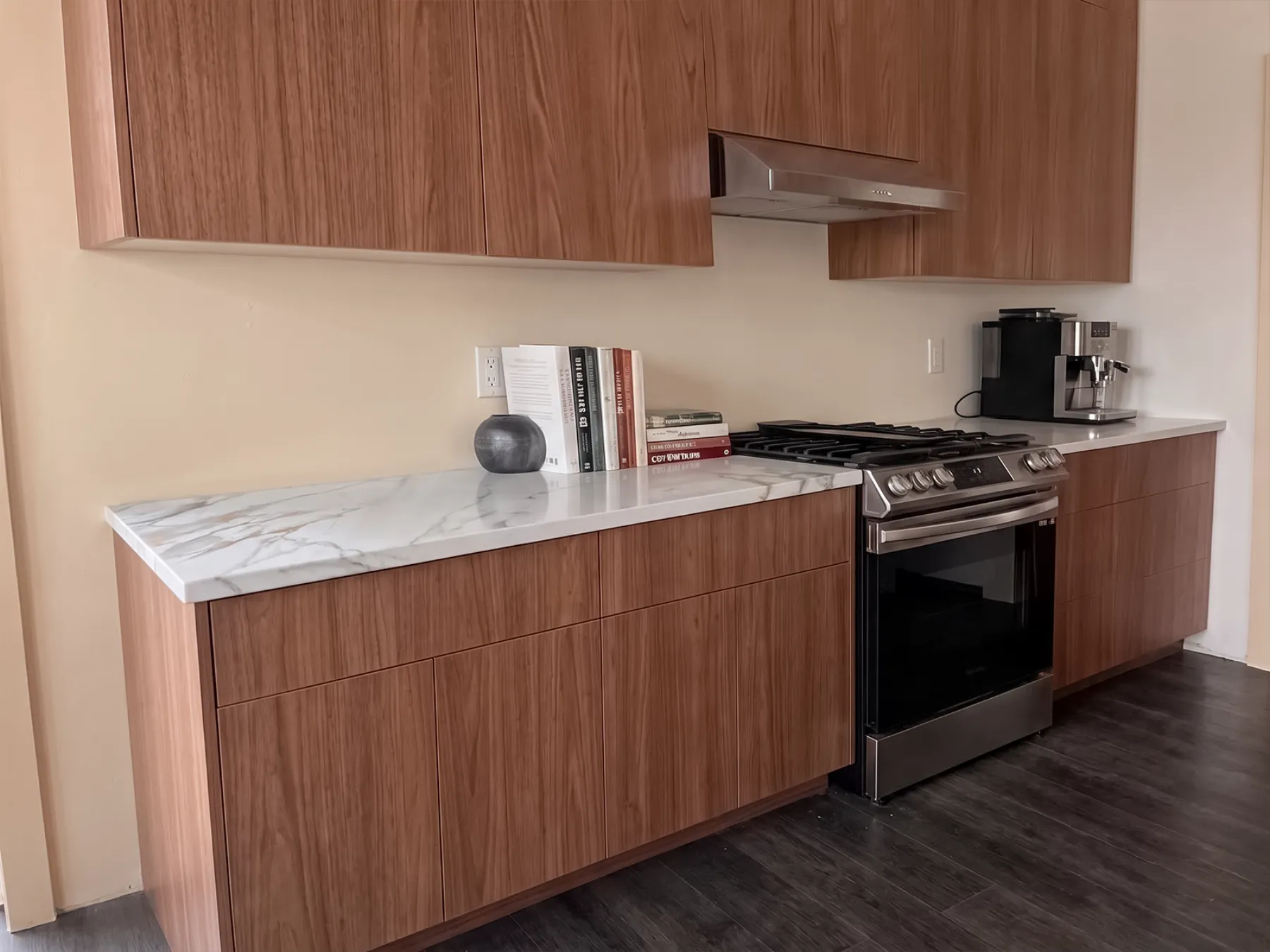 Perimeter counter run in matching quartz against walnut cabinetry